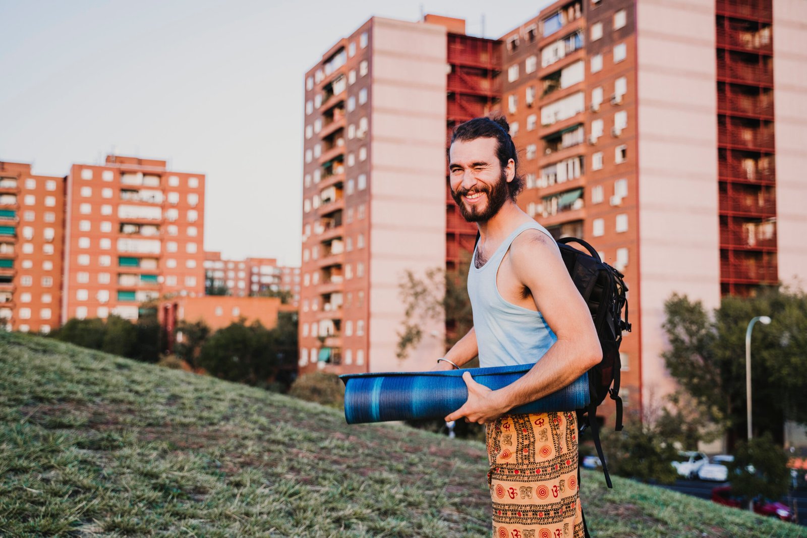 Urban yoga teacher holding a yoga mat with cityscape, exploring how much do yoga instructors make in major cities